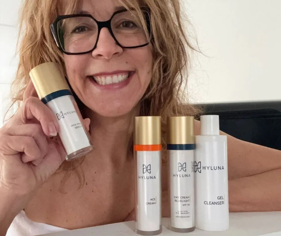 Sabine zeigt ihre Hyluna Routine: Serum in der Hand, daneben ACE Cream, Day Cream SPF 50 und Gel Cleanser als Pflege-Setup.